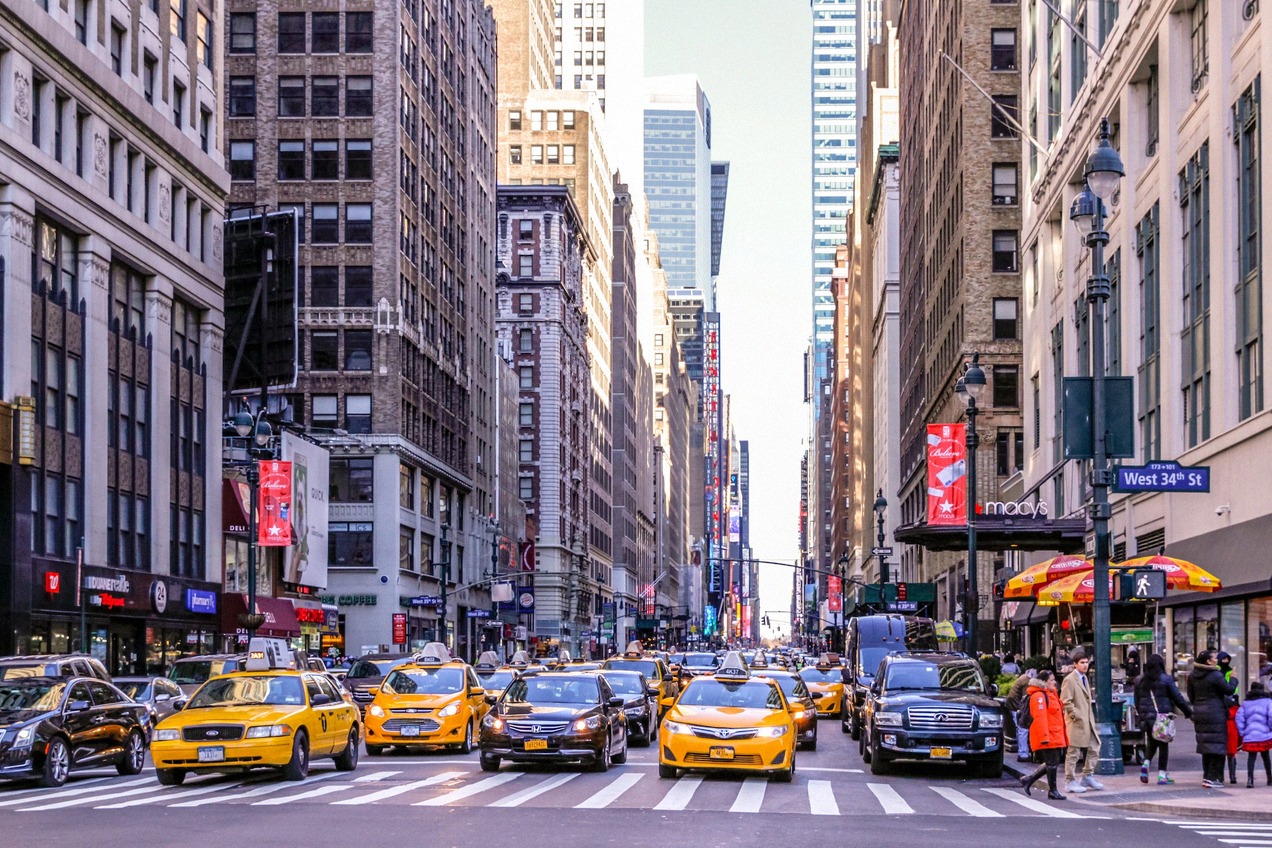 Busy Midtown Manhattan crossing with yellow taxis and high-rises
